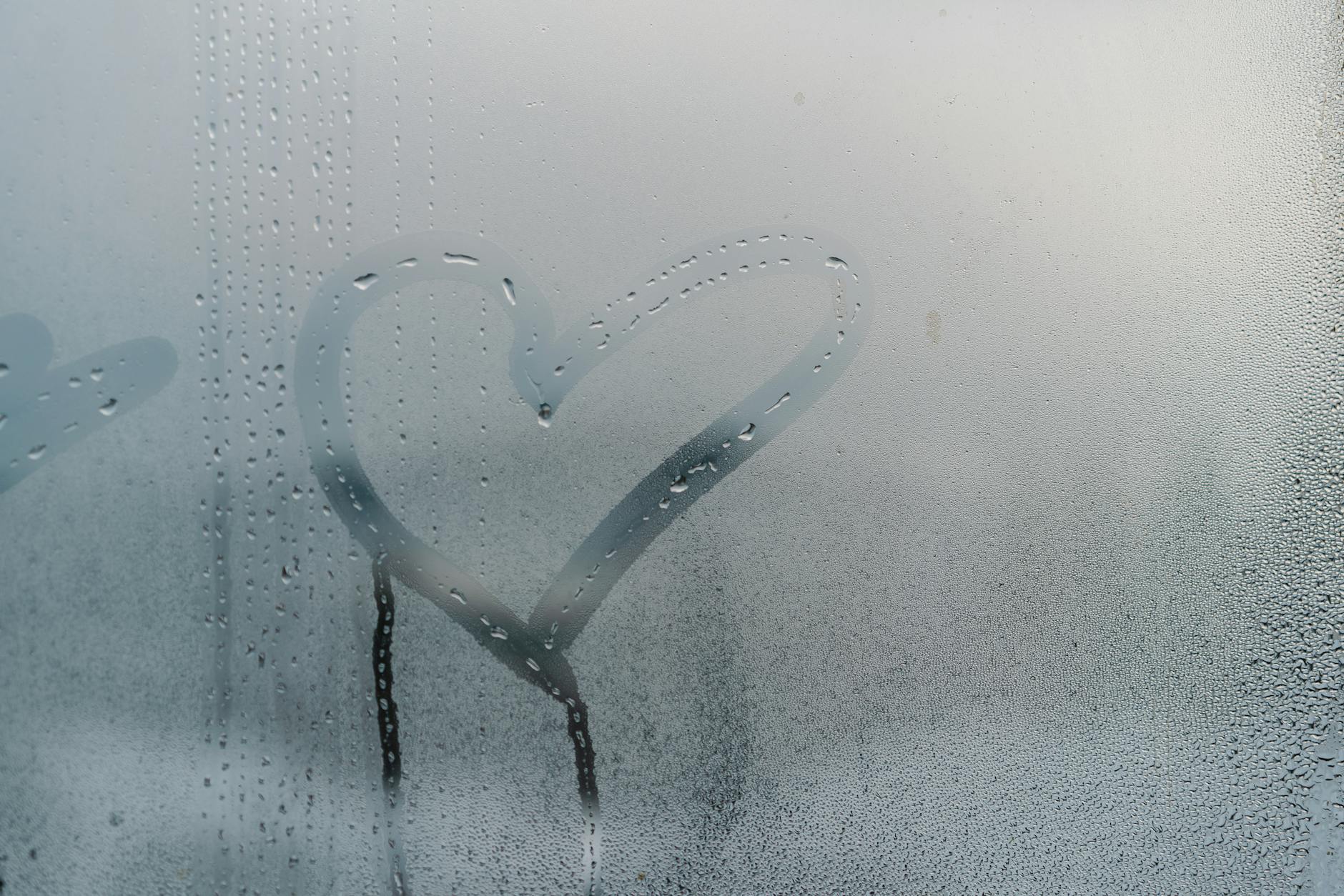 heart drawn over moist glass window